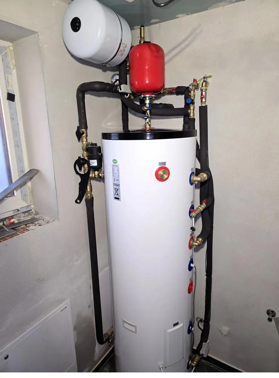 Detailný pohľad na hornú časť kompletnej zostavy kotolne s tepelným čerpadlom AUX R290 — expanzné nádoby, magnetický filter a označené prípojky, realizácia Teplunko v Kotešovej (okres Bytča)